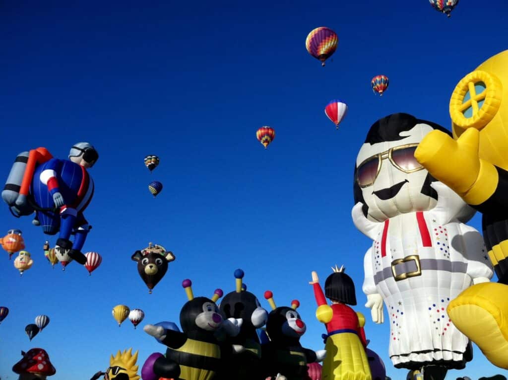 inflatables characters and hot air balloons under blue sky