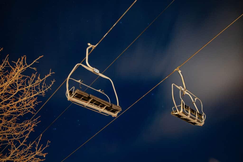 Aspen; two white cable cars under blue and white sky